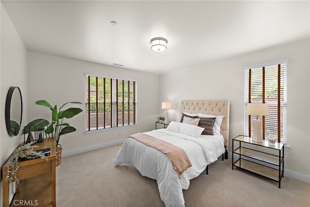 carpeted bedroom with baseboards, visible vents, and multiple windows