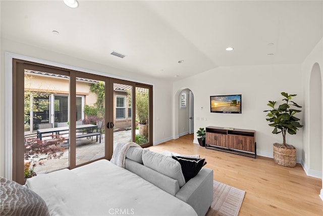 bedroom with arched walkways, visible vents, access to exterior, and light wood-style floors