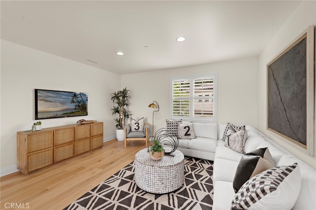 living area featuring light wood-style floors, baseboards, and recessed lighting
