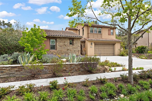 mediterranean / spanish home featuring an attached garage, driveway, a tile roof, and stucco siding