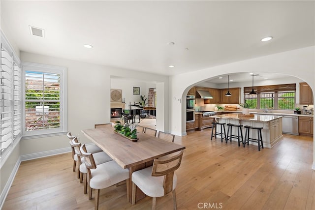 dining room with visible vents, arched walkways, and plenty of natural light