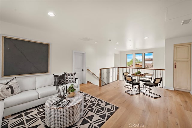 living area with light wood-style floors, recessed lighting, and visible vents