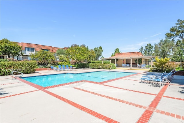 community pool with fence and a patio area