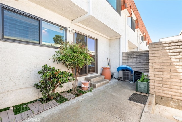 view of patio / terrace with central air condition unit and fence