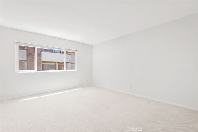 carpeted empty room with baseboards