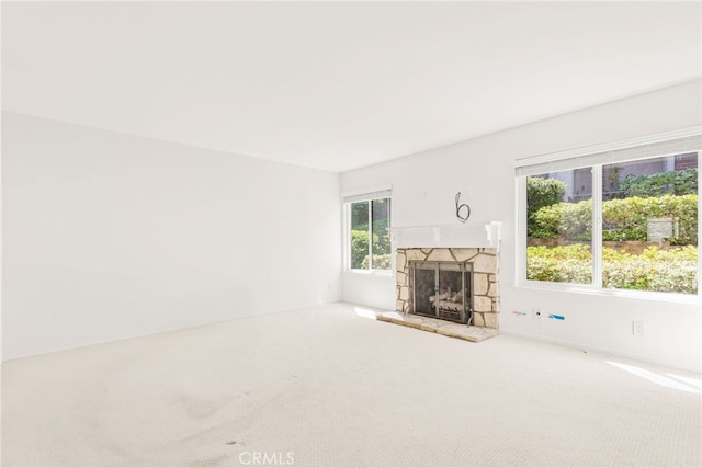 unfurnished living room with a fireplace and carpet