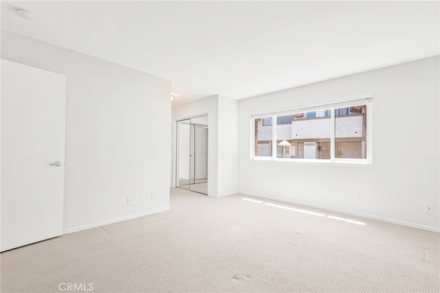 unfurnished room with carpet floors and baseboards