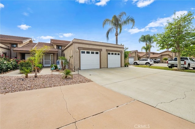 view of front of property featuring a garage, stucco siding, and driveway