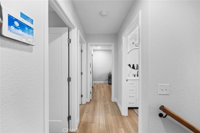 30156 Yellow Feather Dr, Canyon Lake, CA 92587 - corridor featuring light wood-style flooring, a textured wall, baseboards, and a sink
