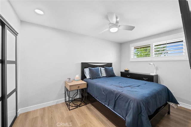 bedroom featuring baseboards, ceiling fan, and light wood-type flooring