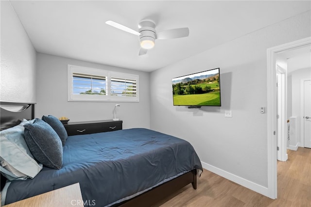 bedroom featuring a ceiling fan, baseboards, and wood finished floors