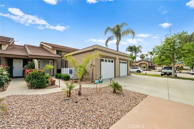 30156 Yellow Feather Dr, Canyon Lake, CA 92587 - view of front of home with concrete driveway, a garage, stucco siding, and central AC unit