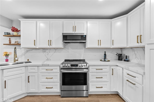 kitchen featuring backsplash, stainless steel appliances, white cabinetry, and a sink