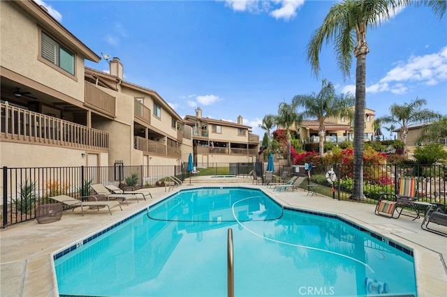 pool with a patio and fence