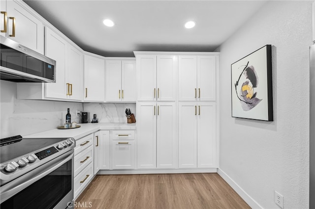 kitchen with light wood finished floors, light countertops, stainless steel appliances, recessed lighting, and white cabinetry