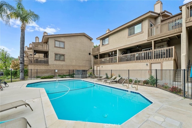 pool with a patio and fence