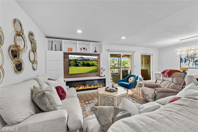 living room with recessed lighting, a glass covered fireplace, and wood finished floors