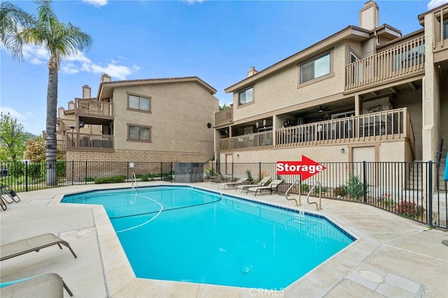 community pool with a patio and fence