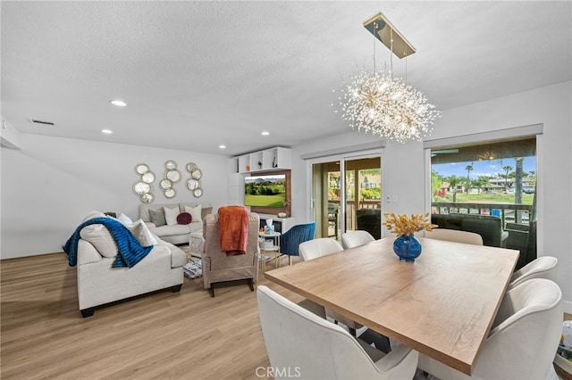 dining area with a textured ceiling, visible vents, light wood-type flooring, a chandelier, and recessed lighting
