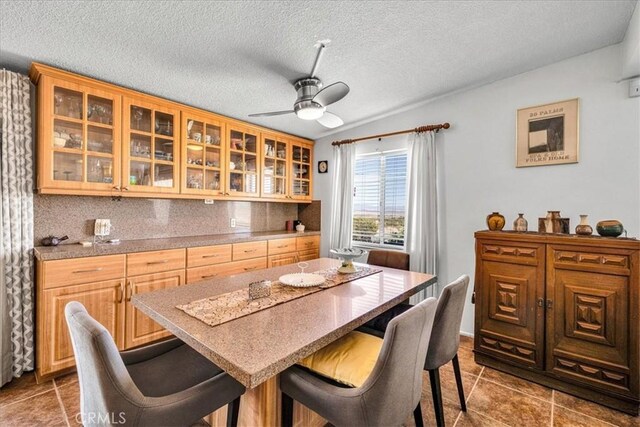 tiled dining area featuring a ceiling fan and a textured ceiling
