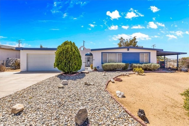 ranch-style house with a garage, fence, stucco siding, and concrete driveway