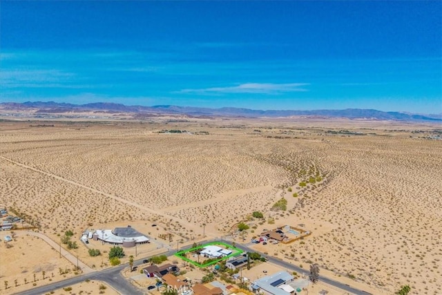 drone / aerial view featuring view of desert, a mountain view, and a rural view