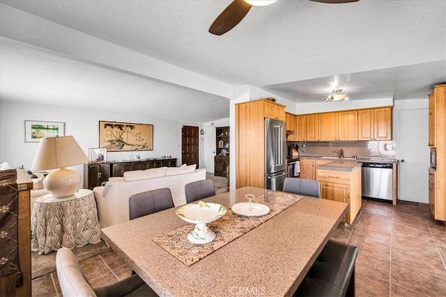 5304 Morongo Rd Unit 29, Palms, CA 92277 - tiled dining space featuring ceiling fan, a textured ceiling, and a sink