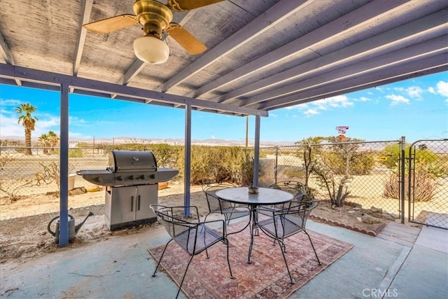 view of patio featuring fence, grilling area, a ceiling fan, and outdoor dining area