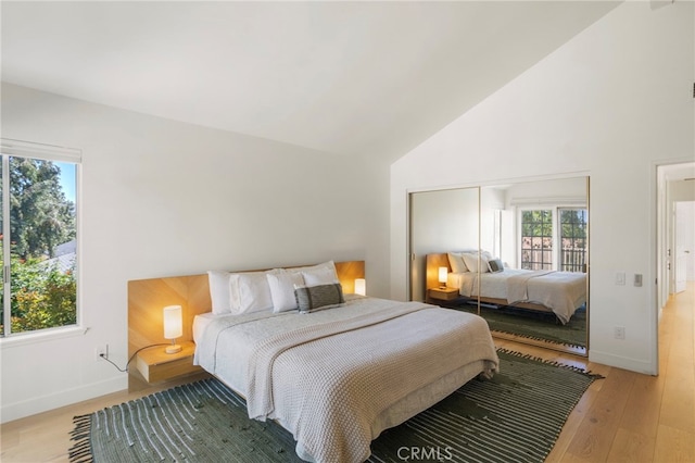 2173 Ranchwood Pl, Riverside, CA 92506 - bedroom featuring multiple windows, light wood-type flooring, high vaulted ceiling, and baseboards