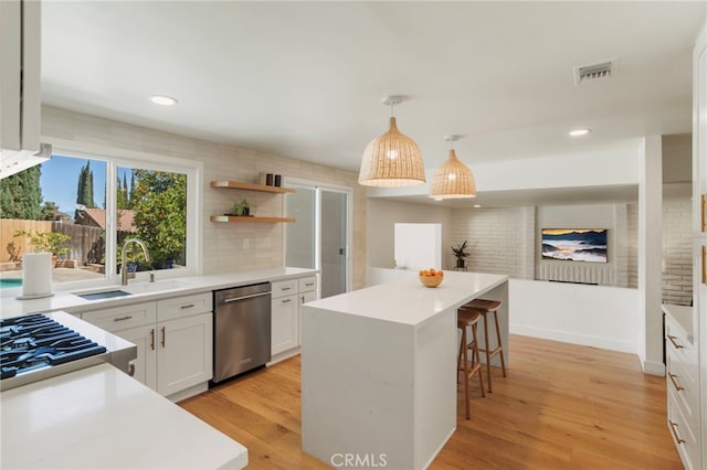 2173 Ranchwood Pl, Riverside, CA 92506 - kitchen with dishwasher, a sink, a kitchen breakfast bar, white cabinets, and a center island