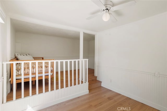 2173 Ranchwood Pl, Riverside, CA 92506 - stairway with wood finished floors, ceiling fan, a wainscoted wall, and ornamental molding