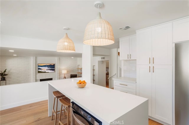 2173 Ranchwood Pl, Riverside, CA 92506 - kitchen featuring light wood finished floors, white cabinetry, light countertops, a center island, and hanging light fixtures