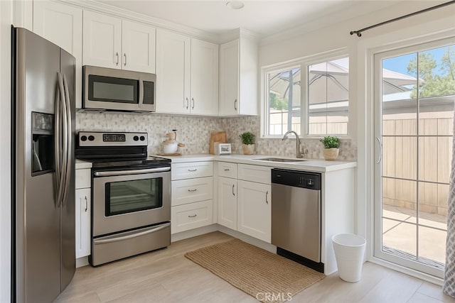 63 Streamwood, Irvine, CA 92620 - kitchen featuring stainless steel appliances, light countertops, white cabinets, backsplash, and a sink