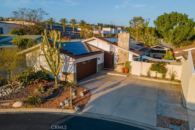 2176 N Pami Cir, Orange, CA 92867 - view of front of home featuring fence, a chimney, roof mounted solar panels, an attached garage, and driveway