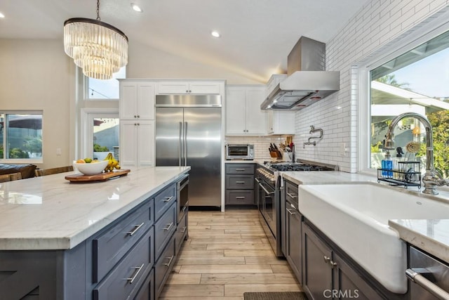 2176 N Pami Cir, Orange, CA 92867 - kitchen with light stone countertops, a sink, wall chimney exhaust hood, white cabinetry, and premium appliances