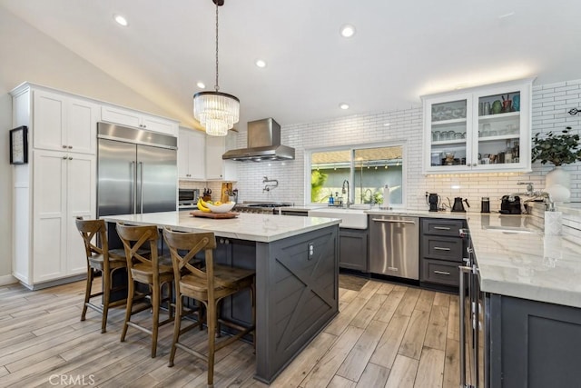 2176 N Pami Cir, Orange, CA 92867 - kitchen featuring wall chimney range hood, decorative backsplash, a sink, stainless steel appliances, and light wood-style flooring