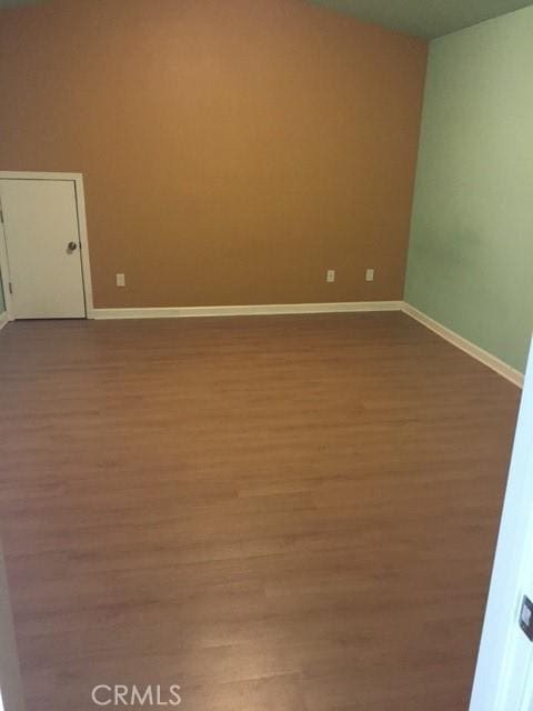 spare room with wood finished floors and baseboards