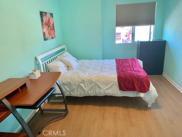 bedroom with baseboards and wood finished floors