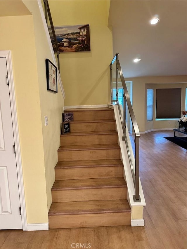 staircase with baseboards, recessed lighting, and wood finished floors