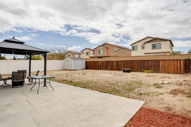 11947 Forest Park Ln, Victorville, CA 92392 - view of patio / terrace featuring a shed, outdoor dining area, a gazebo, and a fenced backyard