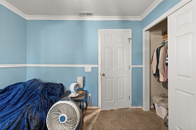 carpeted bedroom with baseboards, visible vents, a closet, and crown molding