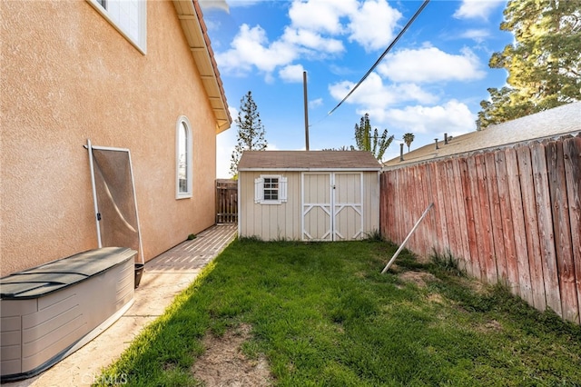 view of yard with a storage unit, an outbuilding, and a fenced backyard