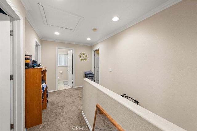 hallway featuring recessed lighting, carpet, attic access, baseboards, and crown molding