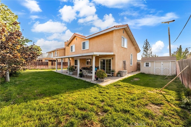 rear view of property with a patio, a fenced backyard, stucco siding, and a storage shed