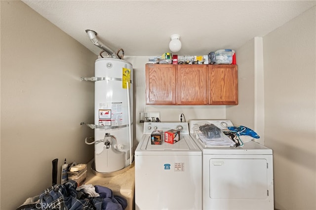 clothes washing area featuring washer and clothes dryer, cabinet space, and strapped water heater