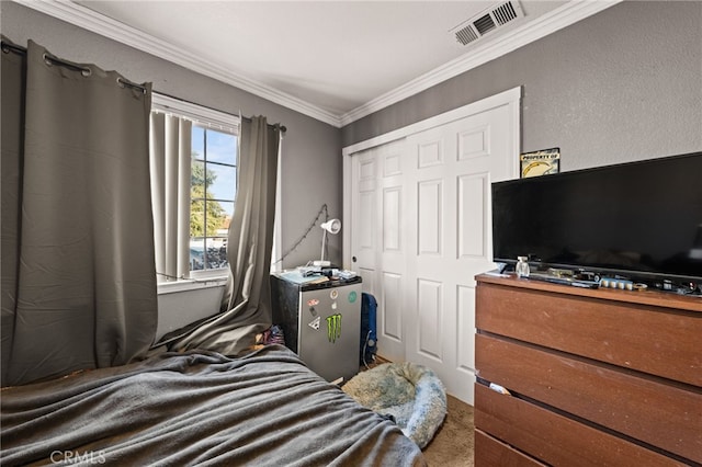 bedroom featuring ornamental molding, a closet, and visible vents