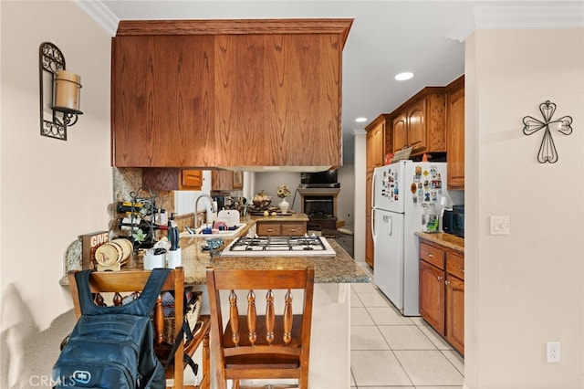 kitchen featuring ornamental molding, a sink, a peninsula, and white appliances