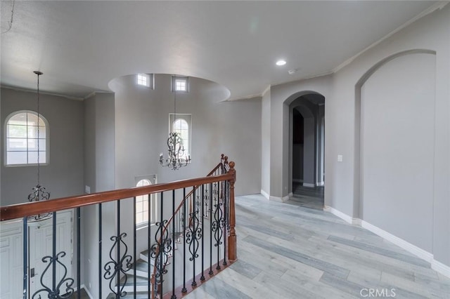 1059 Stowell Ranch Cir, Corona, CA 92881 - corridor featuring ornamental molding, arched walkways, light wood-style flooring, and baseboards