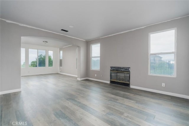 1059 Stowell Ranch Cir, Corona, CA 92881 - unfurnished living room featuring a glass covered fireplace, wood finished floors, baseboards, and arched walkways