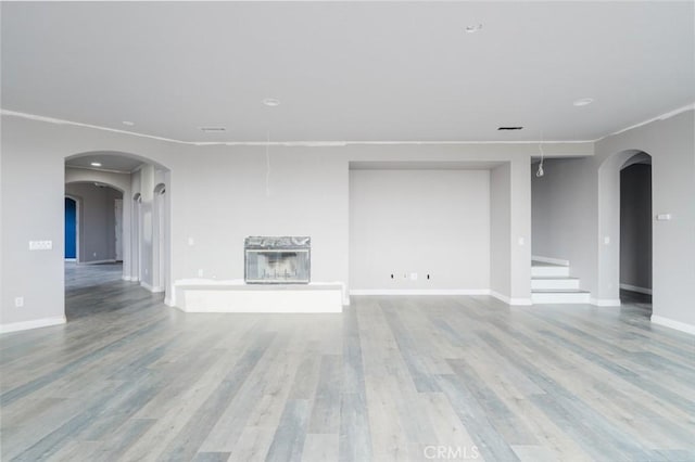 1059 Stowell Ranch Cir, Corona, CA 92881 - unfurnished living room with baseboards, wood finished floors, and arched walkways